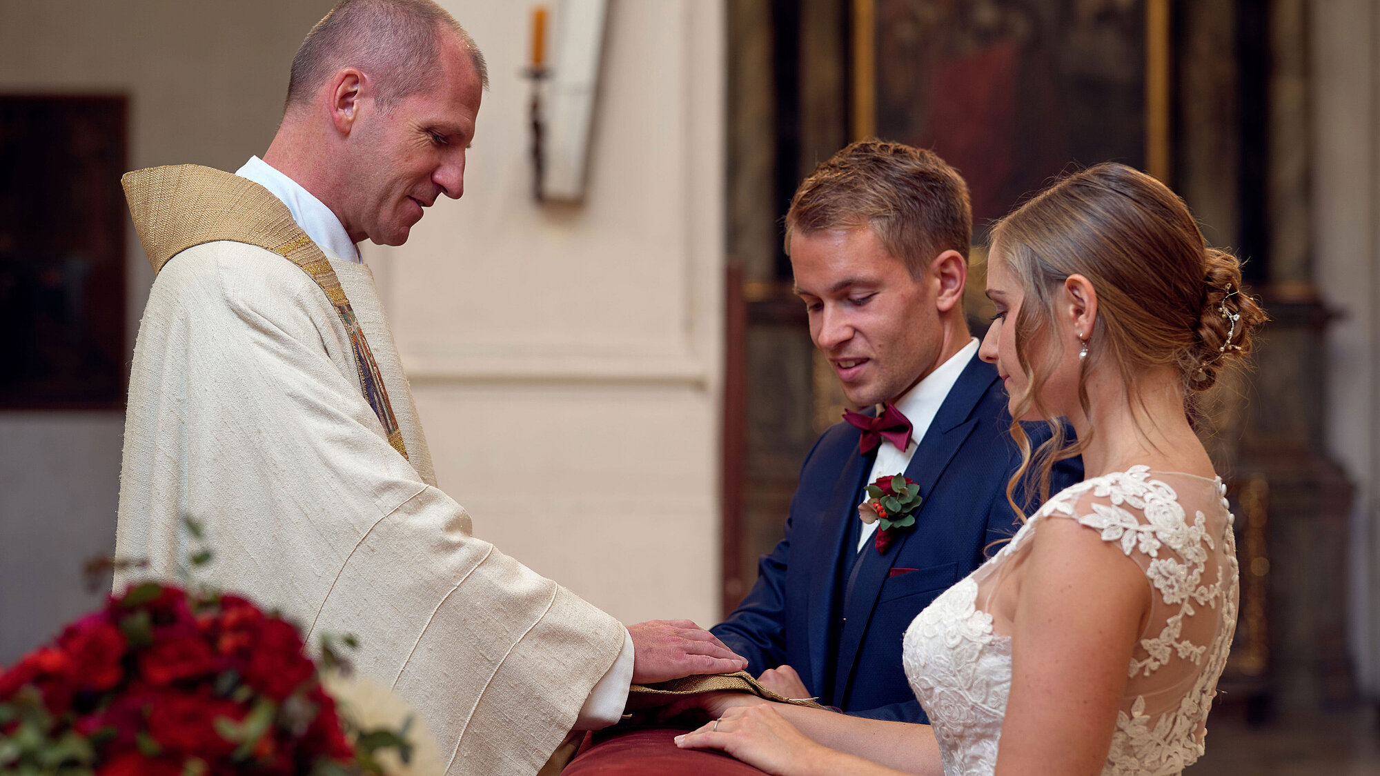 Ein junges Paar erhält bei der kirchlichen Trauung den priesterlichen Segen.