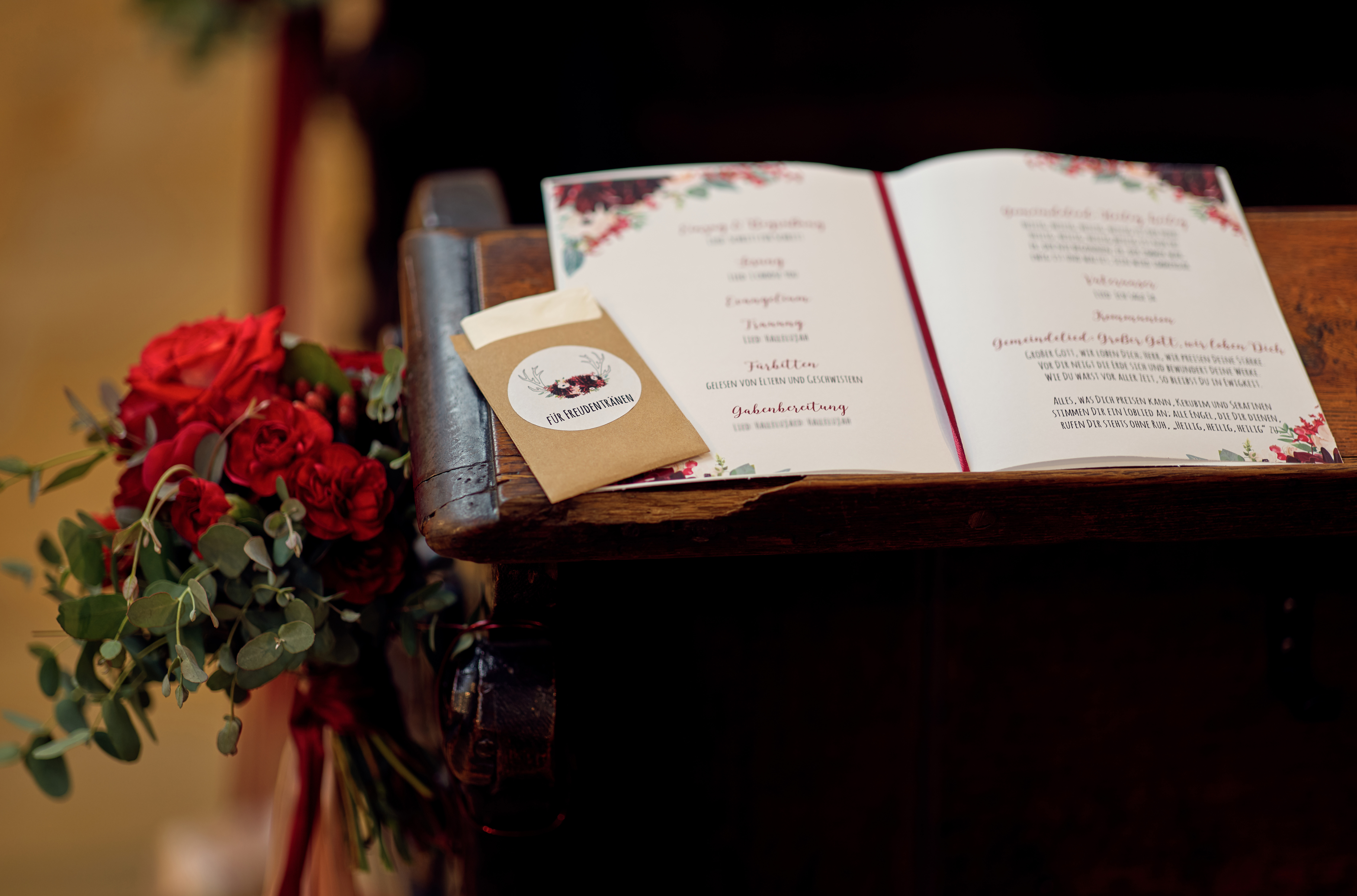 Nahaufnahme auf das Programmheft einer kirchlichen Hochzeit, das auf einer Kirchenbank liegt.